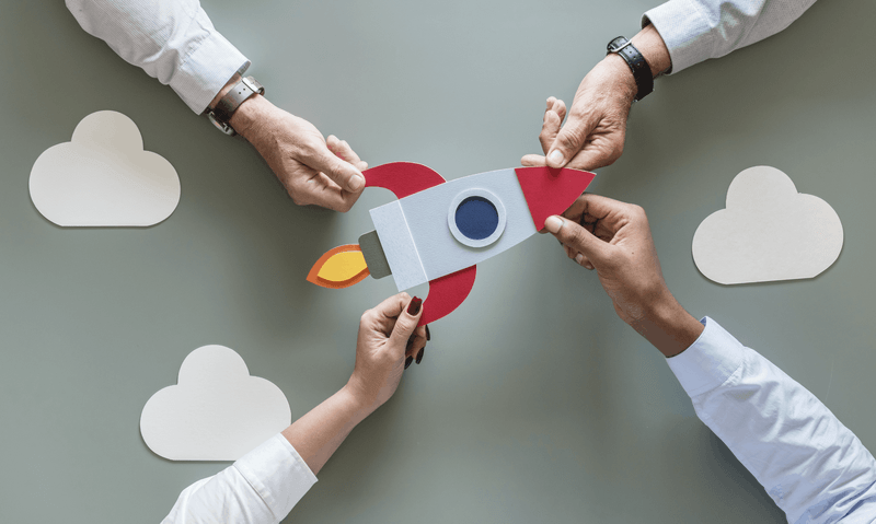 People holding a paper spaceship