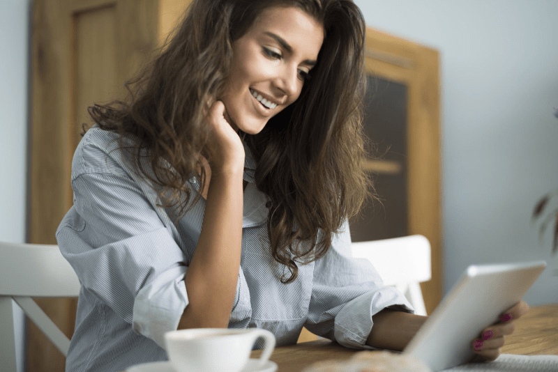 Woman browsing her tablet in the morning